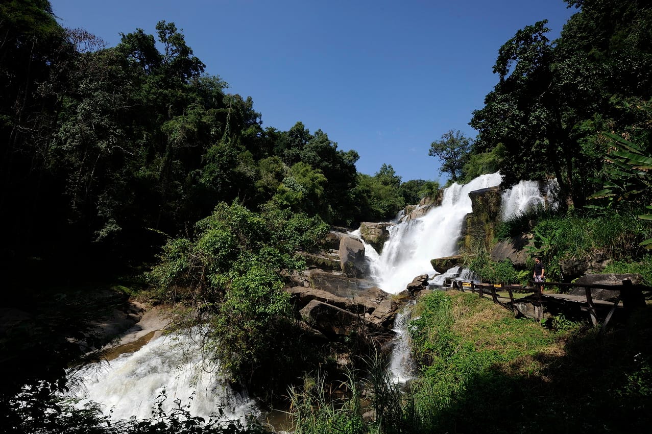 Mae Klang waterfall cascading over dark rock steps into the forest at the foot of Doi Inthanon