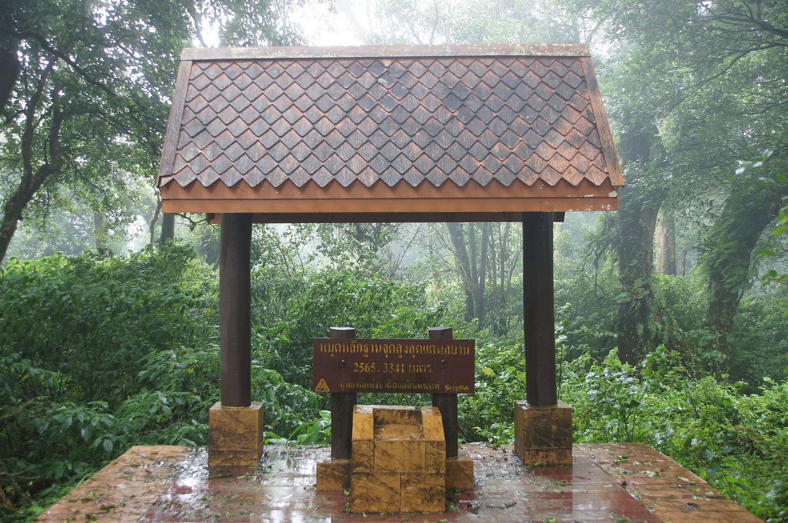 Marker recording the highest point in Thailand, 2,565 m, under its tiled shelter in the mist at the Doi Inthanon summit