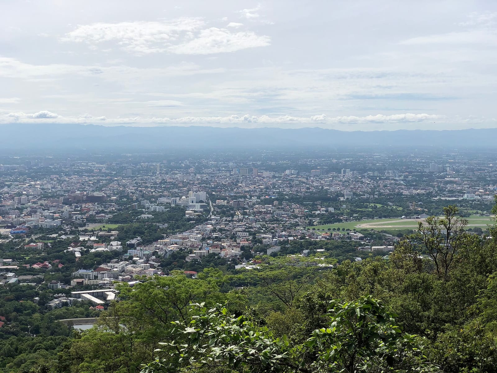 View east over Chiang Mai city from the Doi Suthep terrace, with the airport runway in the middle distance