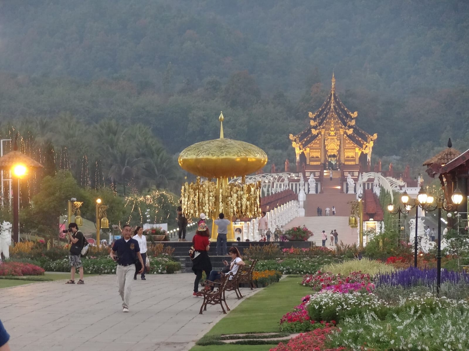 Ho Kham Luang and the golden Bo tree sculpture illuminated at dusk at Royal Flora Ratchaphruek