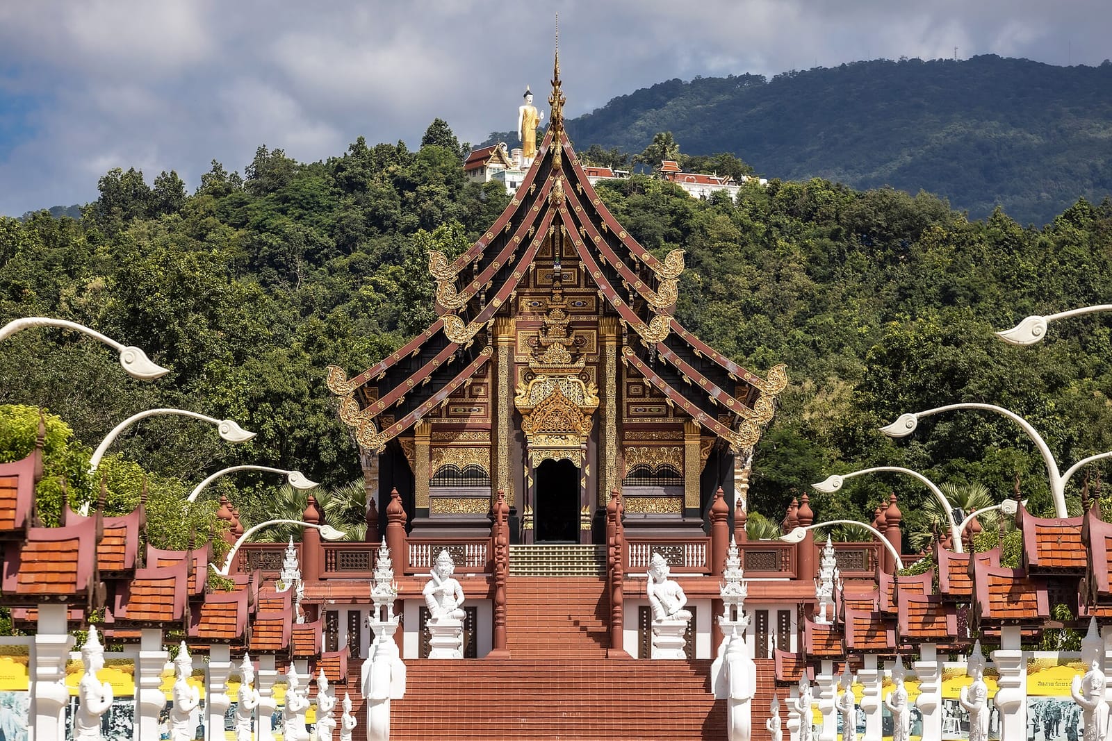 Carved gable façade of Ho Kham Luang seen from the approach avenue at Royal Flora Ratchaphruek