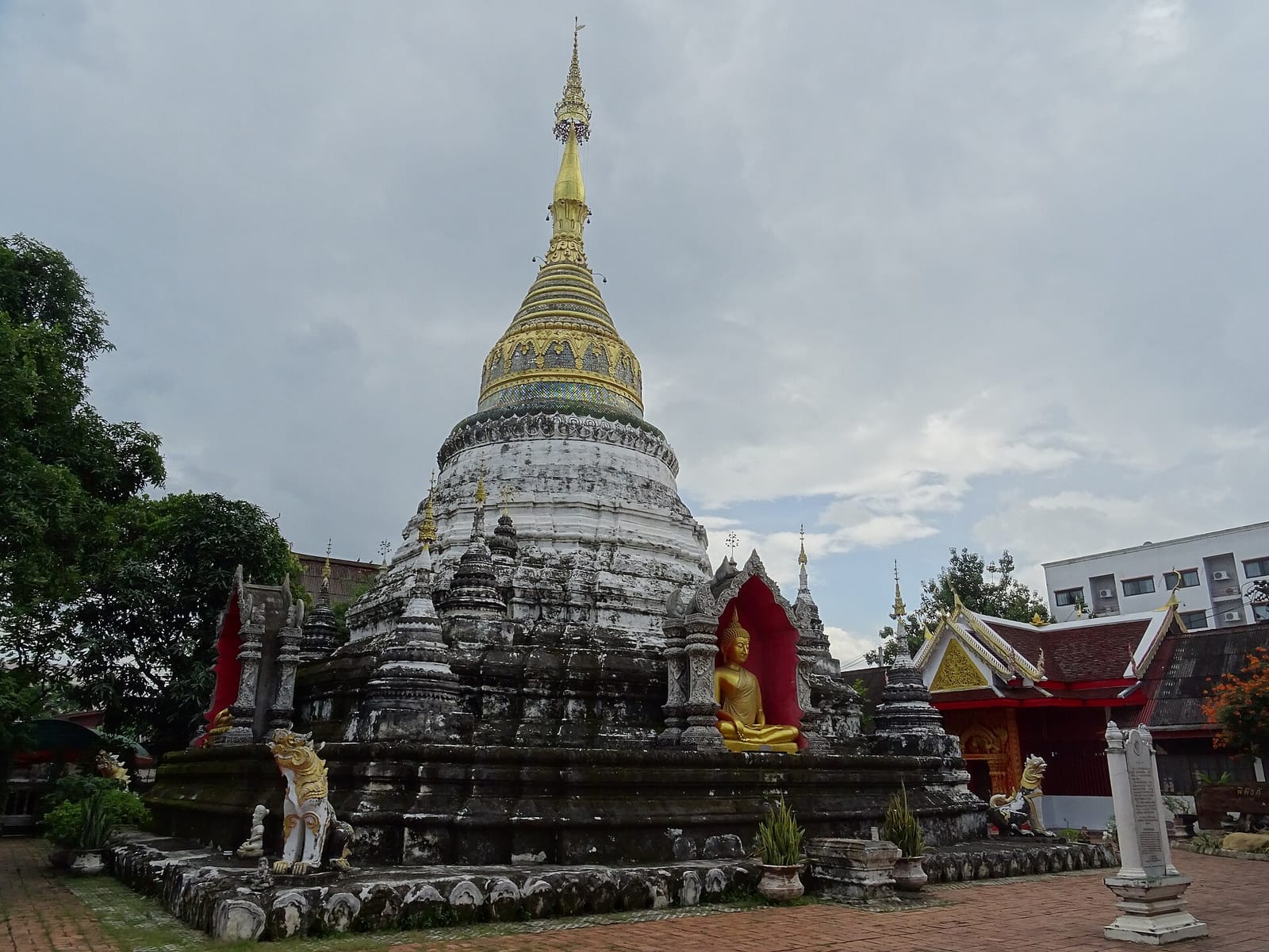 Burmese-style chedi at Wat Bup Pha Ram with stepped base, whitewashed dome and tall gilded spire