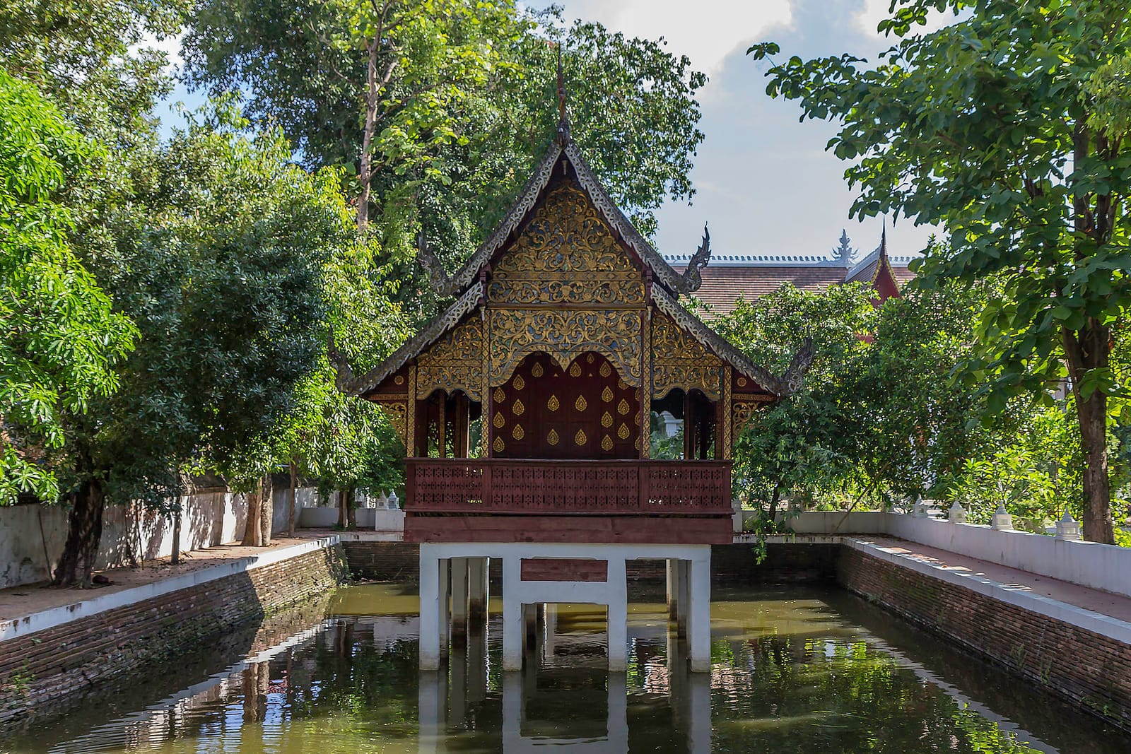 Rectangular pond at the southern edge of the compound, with the teak ho trai library raised above the water