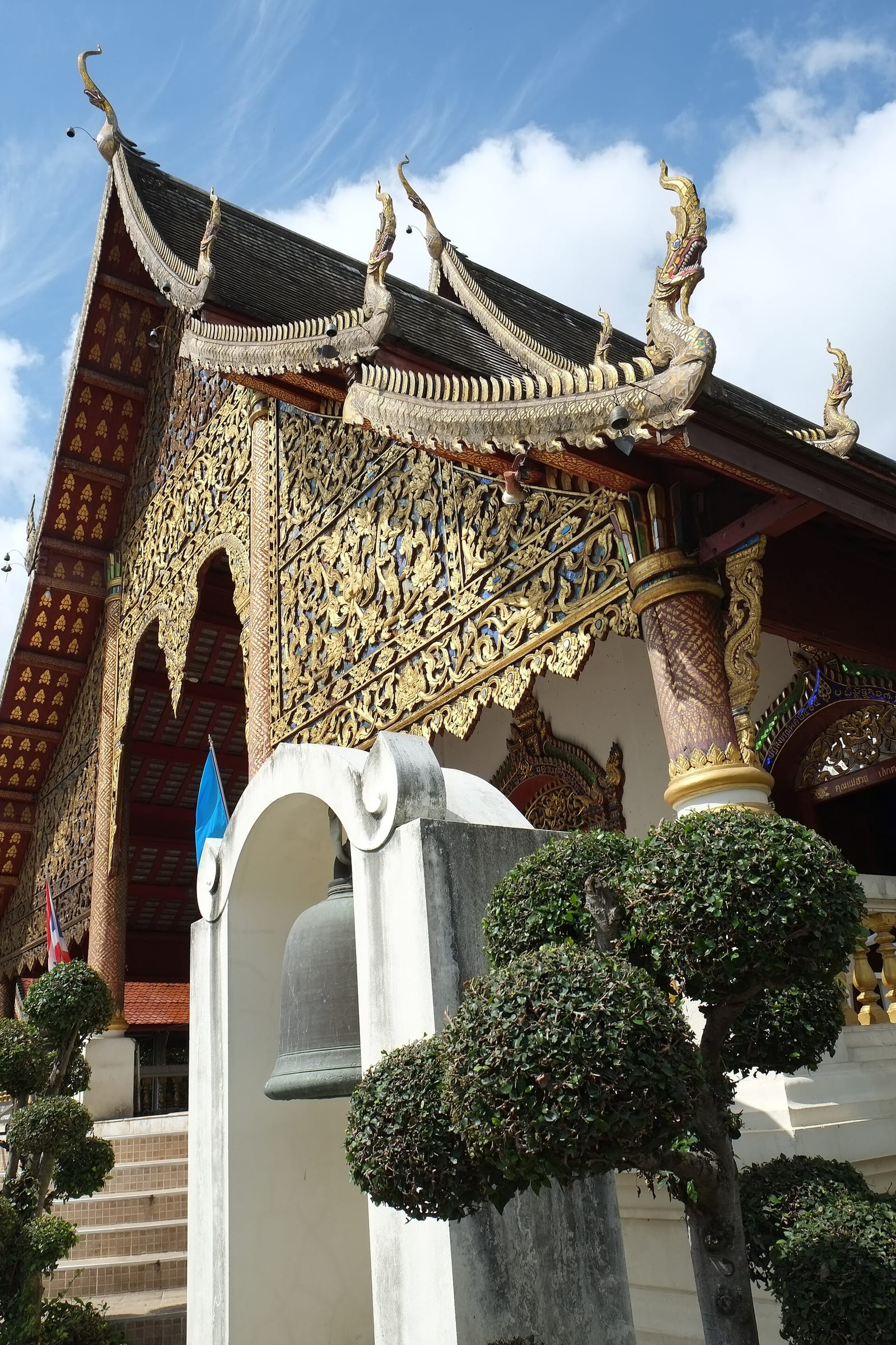 Ordination hall of Wat Chiang Man with serpent finials on the gable ends and the temple bell by the entrance