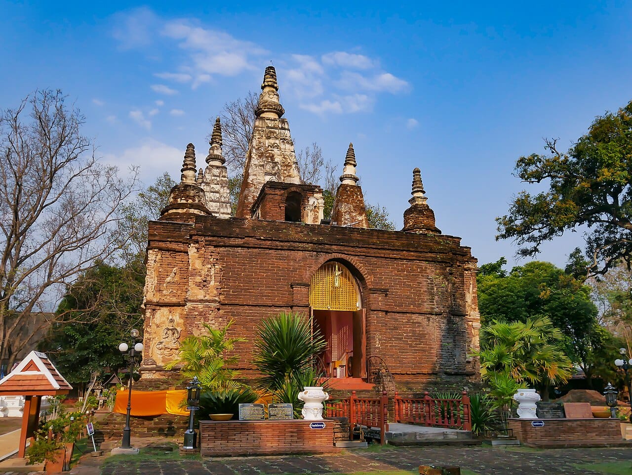 Front view of the Mahabodhi-style chedi showing the spires and the inset doorway at the base