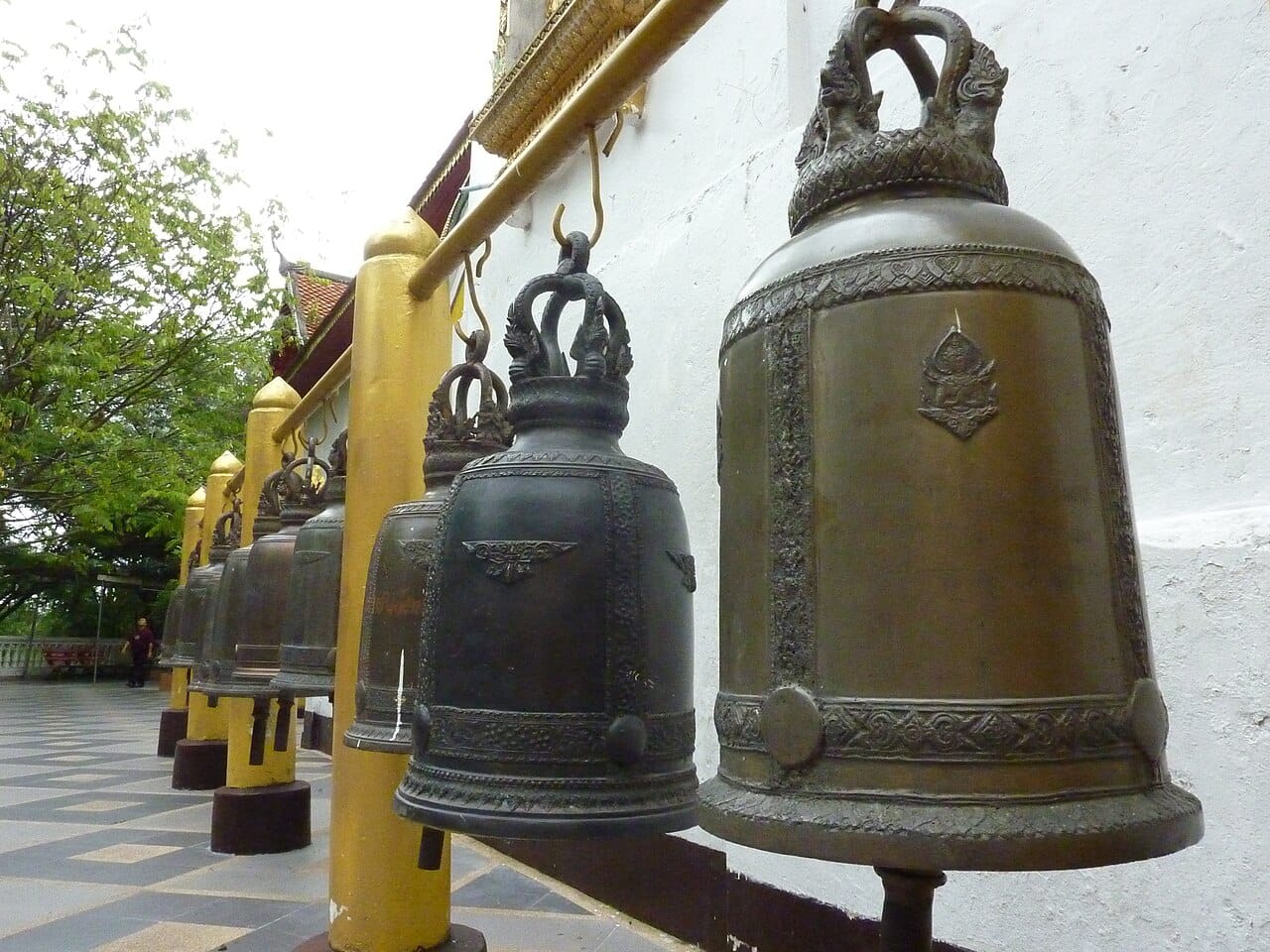 Row of bronze prayer bells along the outer cloister, struck by visitors for good fortune
