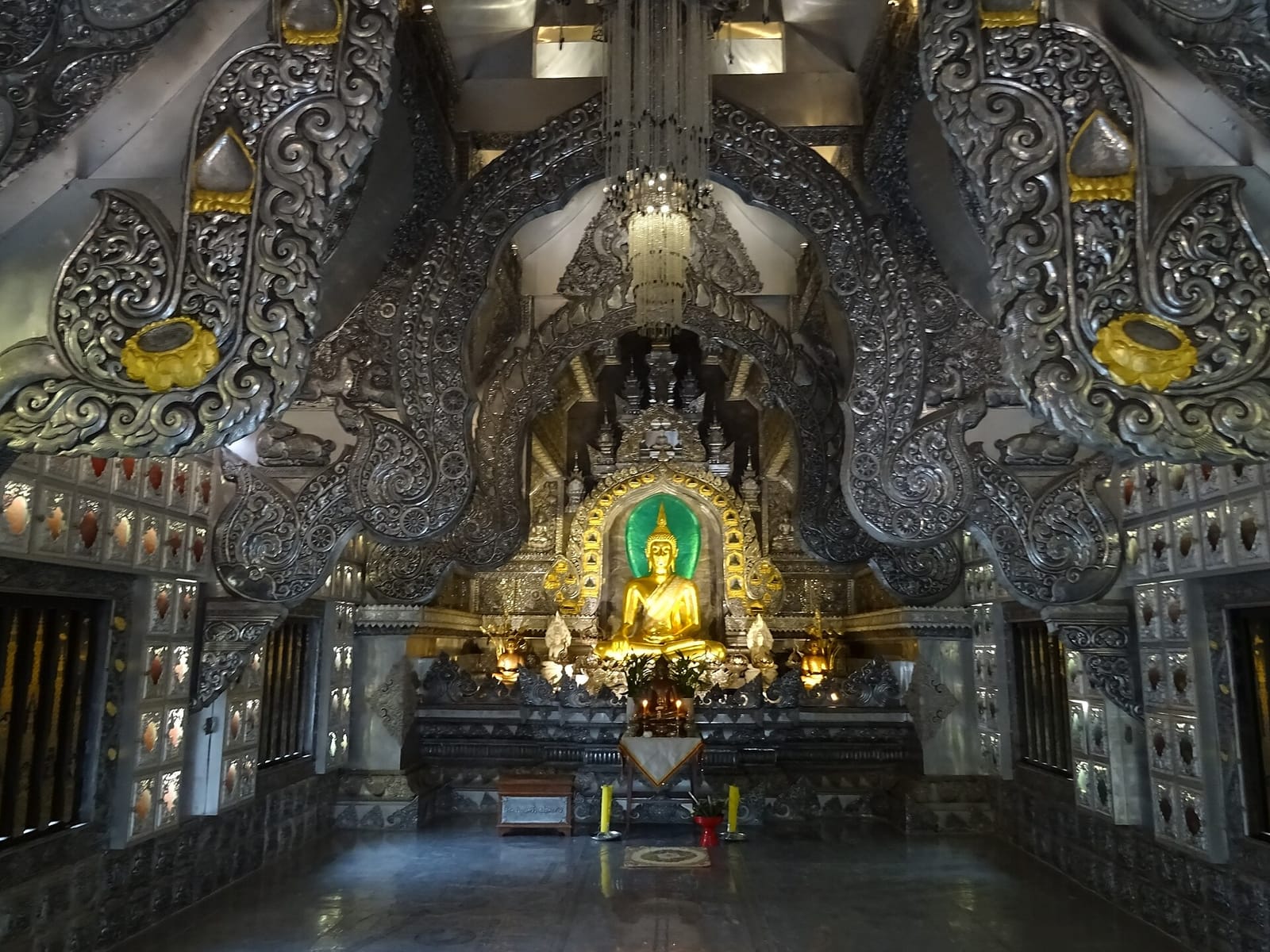 The principal Buddha image inside the silver ubosot, surrounded by silver wall panels