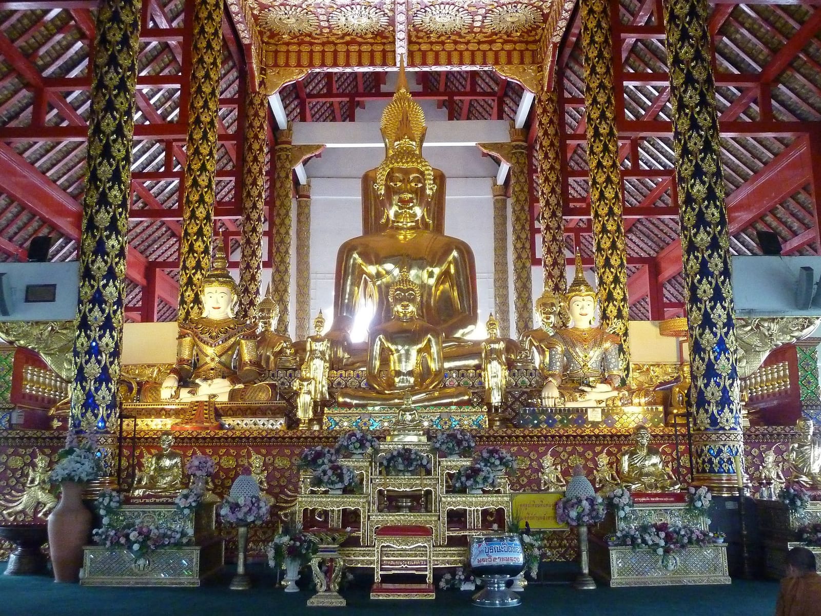 Principal Buddha image group on the high gilded altar inside the main viharn of Wat Suan Dok