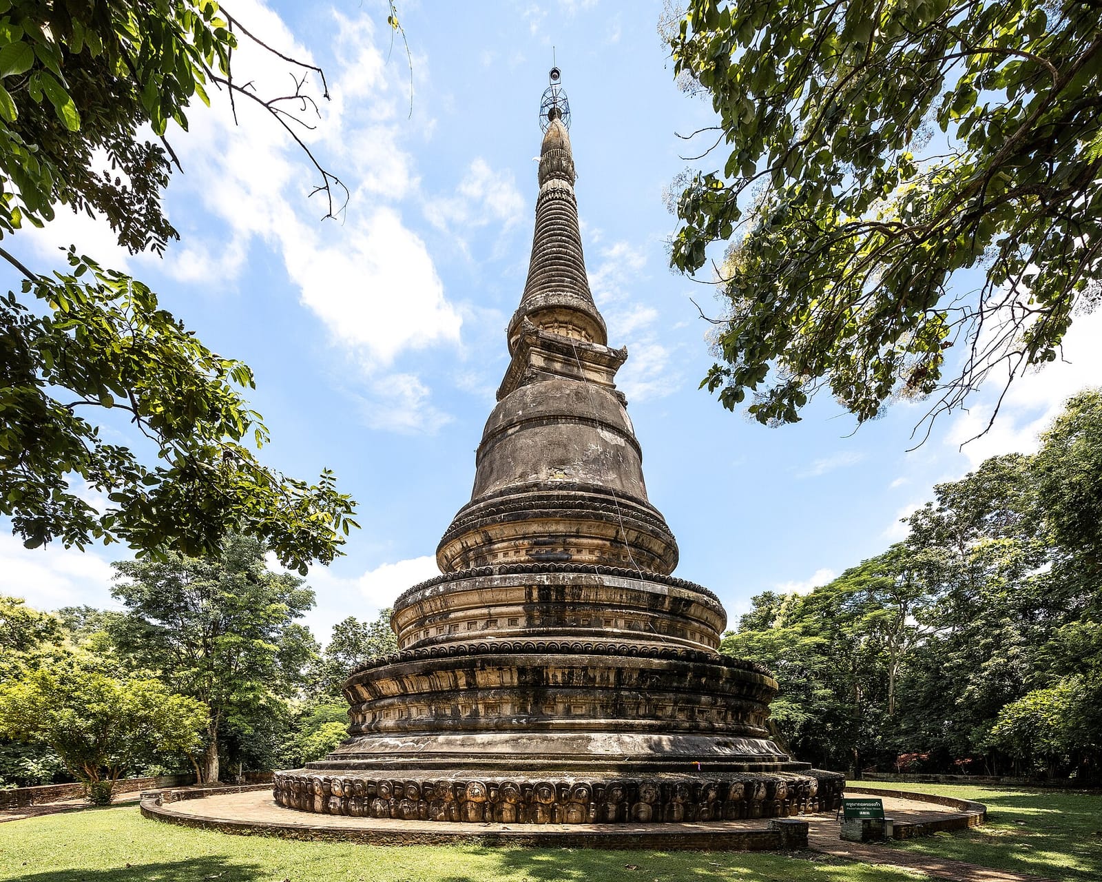 The ancient weathered Lanna chedi above the tunnel system at Wat Umong, framed by forest trees